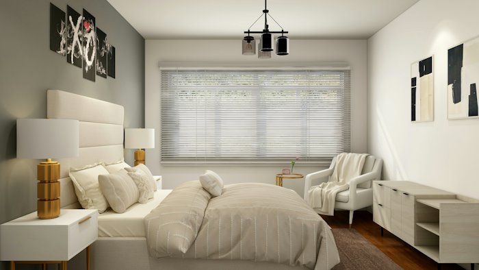 A bedroom with a made bed, blinds and an armchair