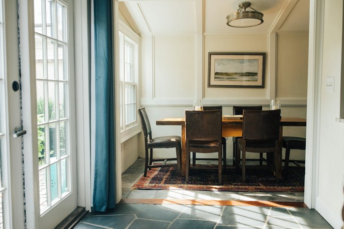 A wooden dining table and chairs in a bright kitchen